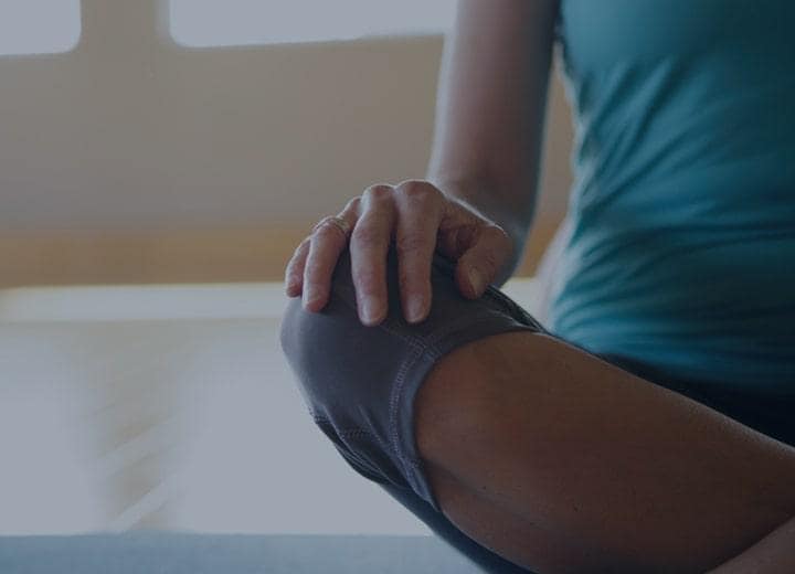 a woman sitting with her legs crossed doing yoga