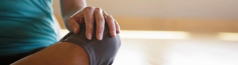 a woman sitting with her legs crossed doing yoga